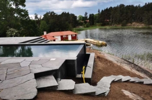 Liten pool på träaltan i en liten trädgård med funktionell och stilren utformning