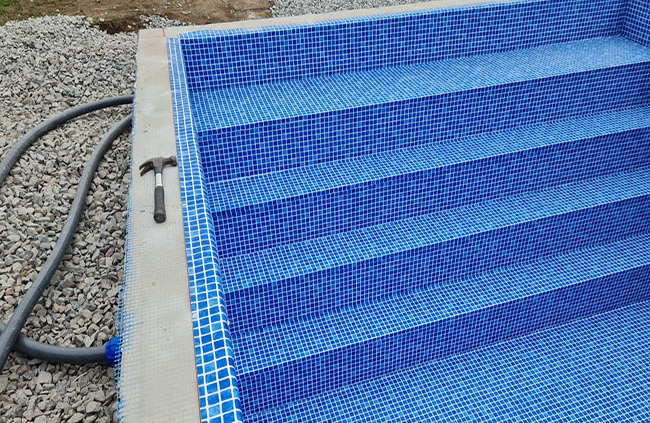 Ovan mark-pool med blå mosaikliner – ett poolprojekt med kort byggtid