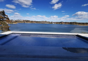 Pool med utsikt över sjö i naturnära miljö