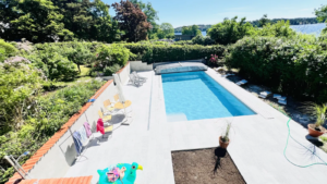 Pool i villaträdgården med altan och planerad uteplats